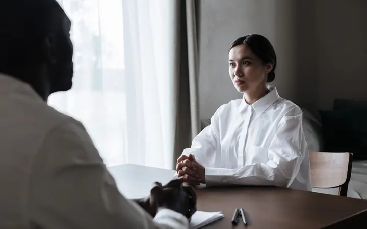 A recruiter interviewing a candidate across a desk